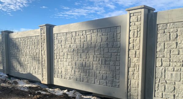 Sturdy and aesthetically pleasing precast concrete fence with intricate stone texture design, showcasing Westcon's quality craftsmanship in residential or commercial boundary solutions.