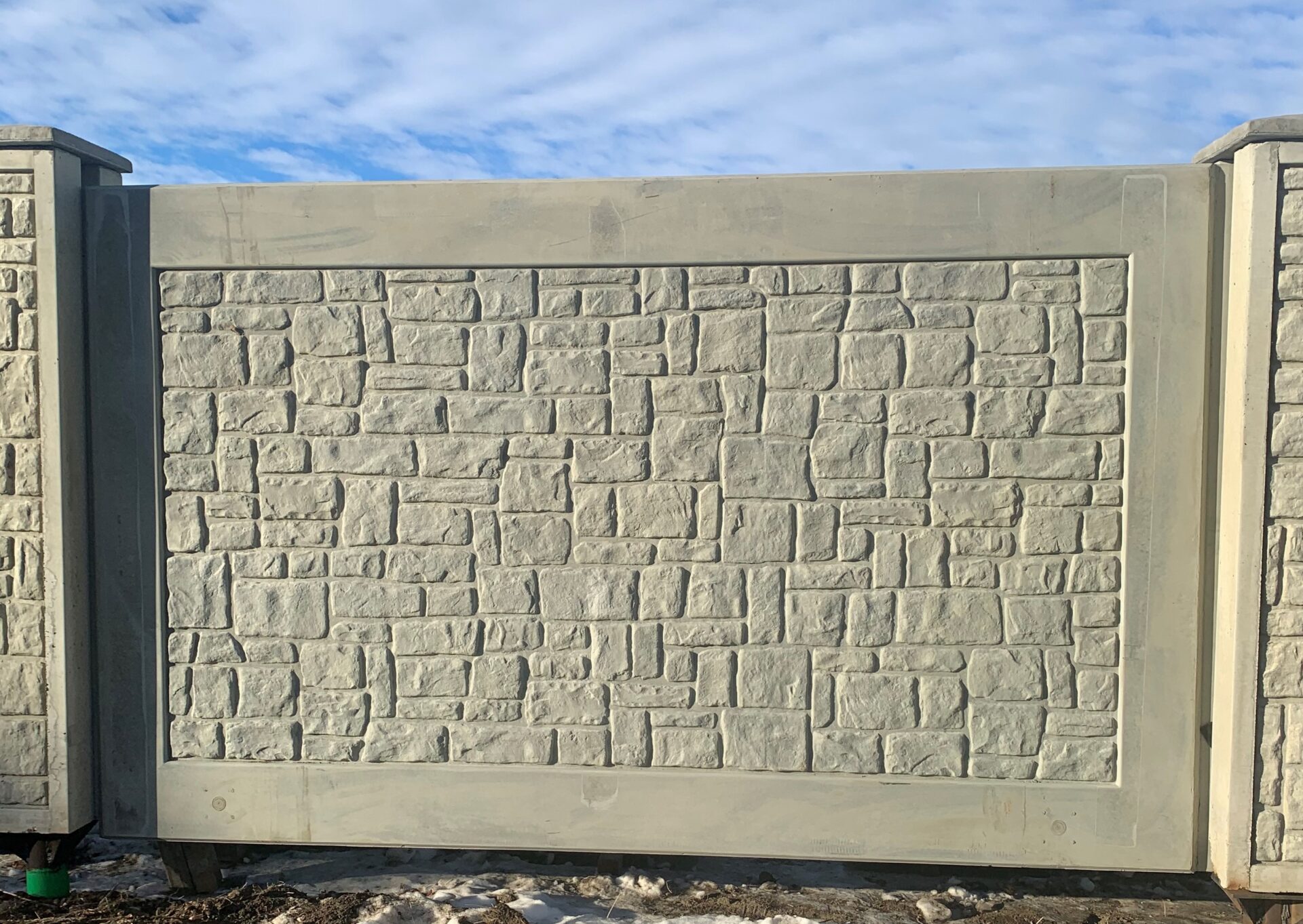 Sturdy and aesthetically pleasing precast concrete fence with intricate stone texture design, showcasing Westcon's quality craftsmanship in residential or commercial boundary solutions.